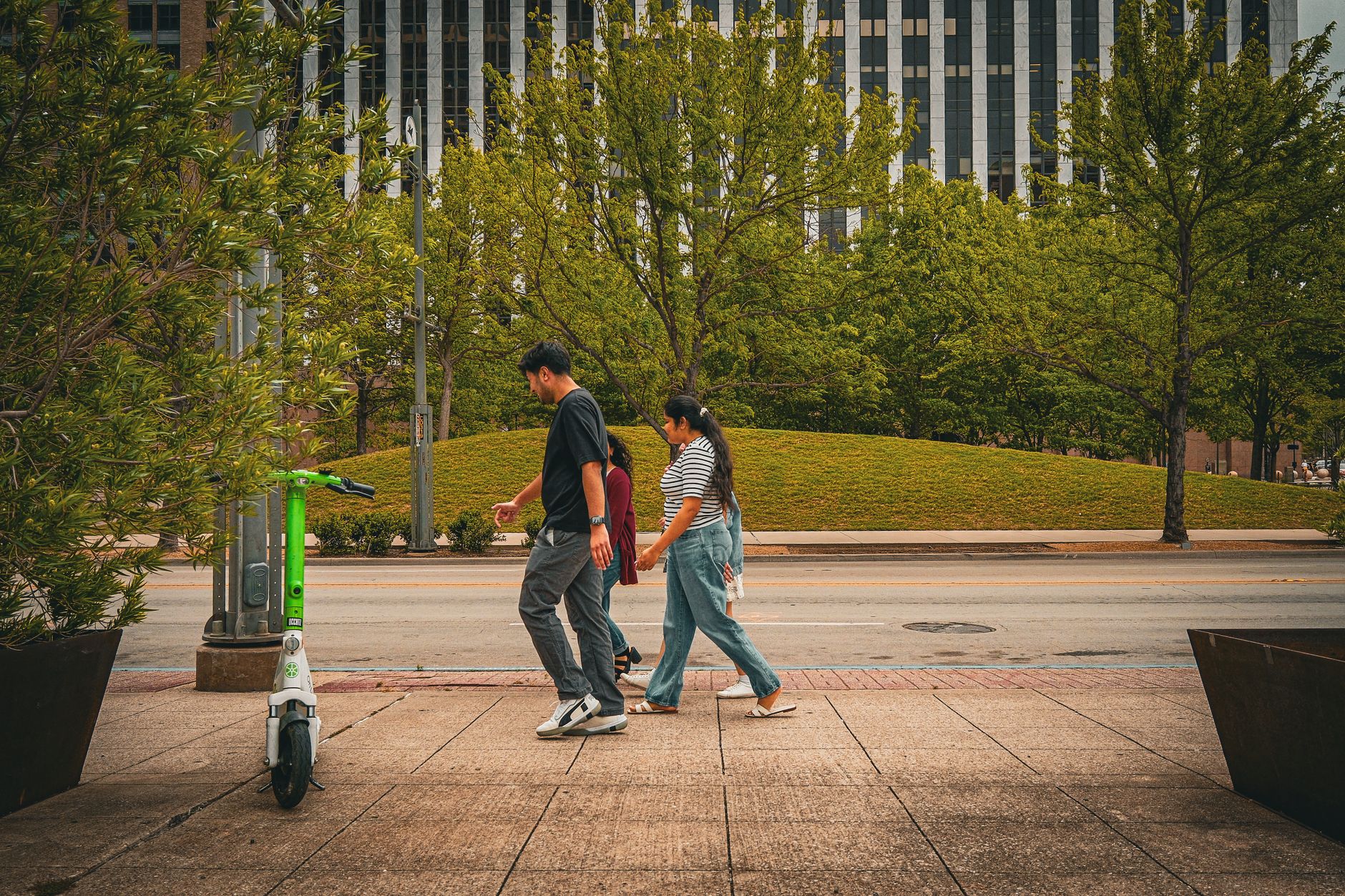 People walking beside greenery on a Dallas street